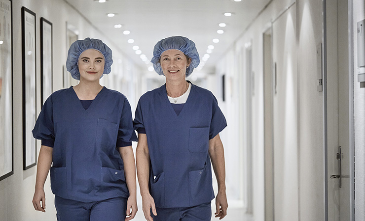 To sygeplejersker kommer gående ned ad gangen