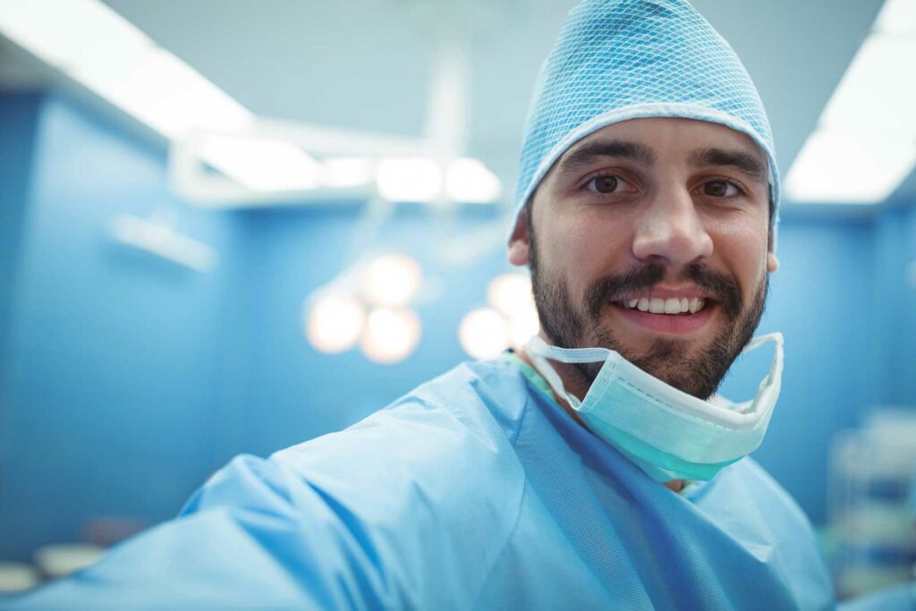 Idrætskirurg med masken om halsen smiler